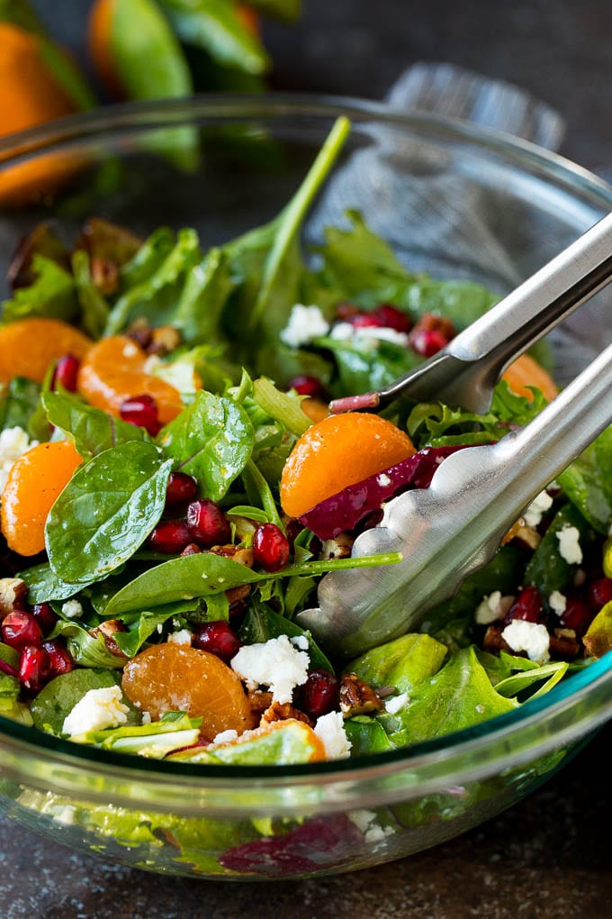 Tongs serving up a portion of Christmas salad.