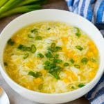 A bowl of egg drop soup garnished with green onions.
