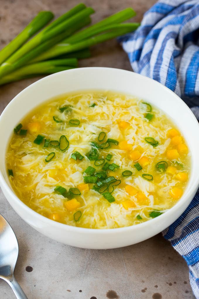 A bowl of egg drop soup garnished with green onions.