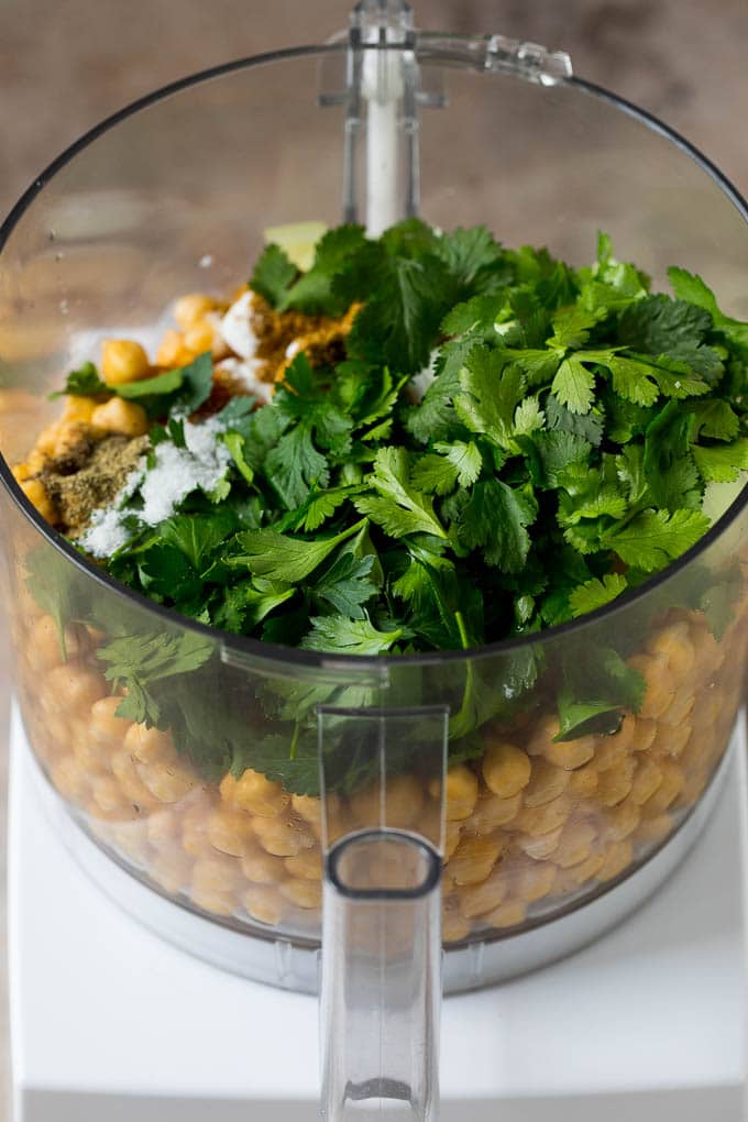 Chickpeas, herbs and seasonings in a food processor.