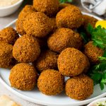 A platter of falafel garnished with parsley and lemon.