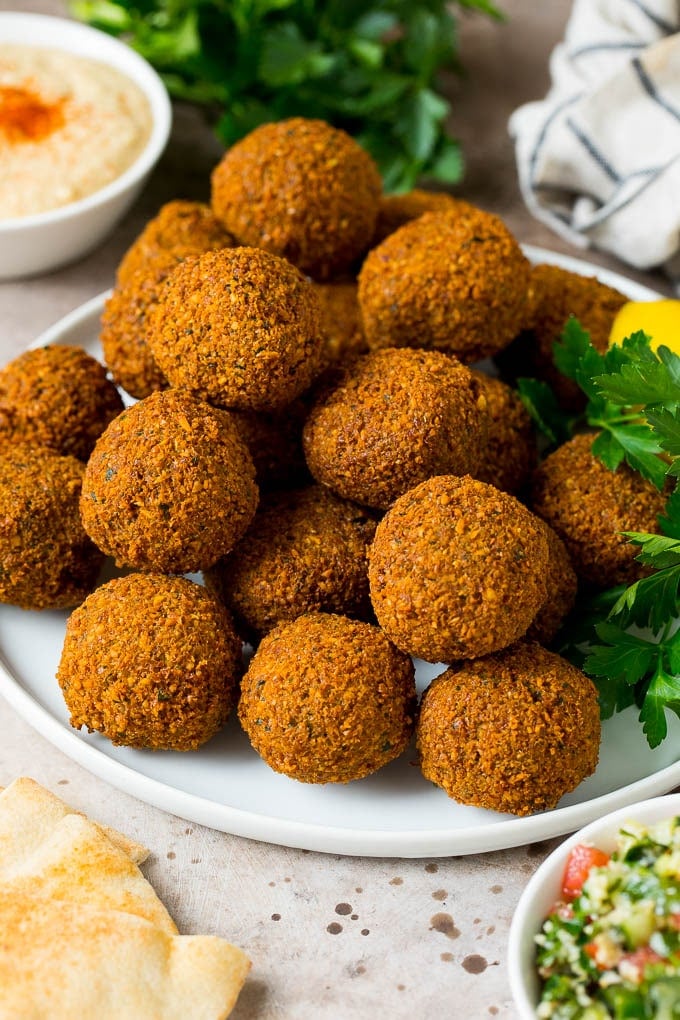 A platter of falafel garnished with parsley and lemon.