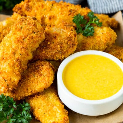 A bowl of honey mustard sauce served with chicken fingers.