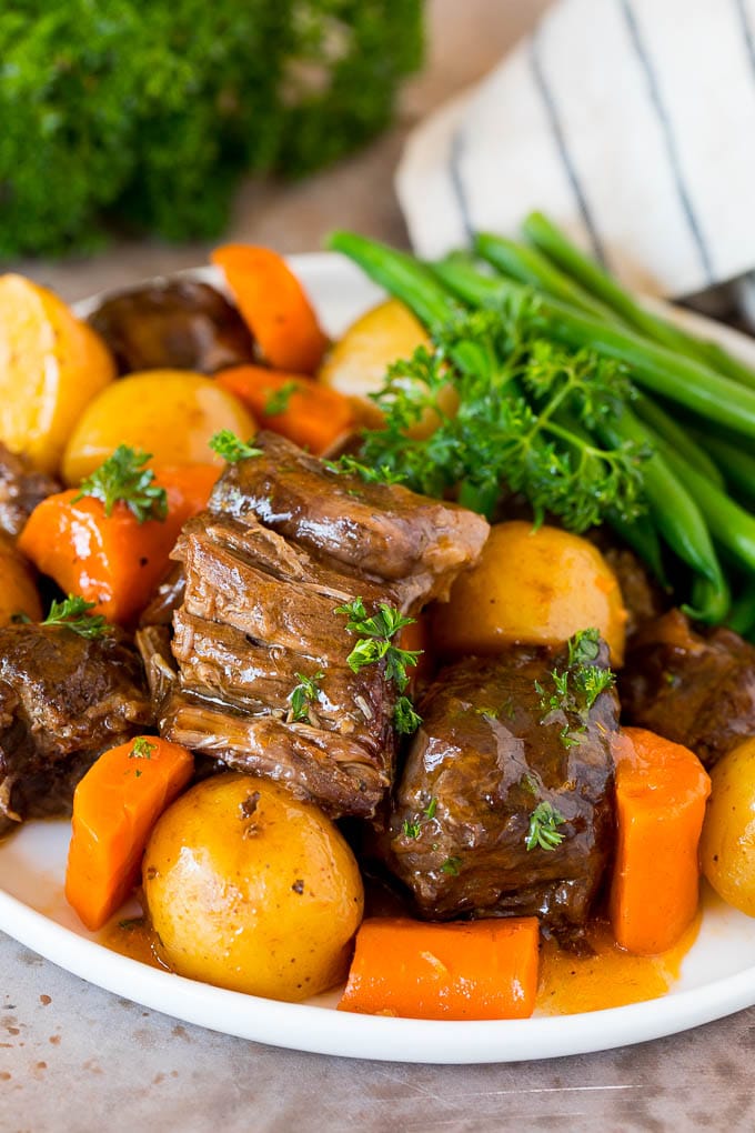 A plate of Instant Pot pot roast served with carrots, green beans and potatoes.