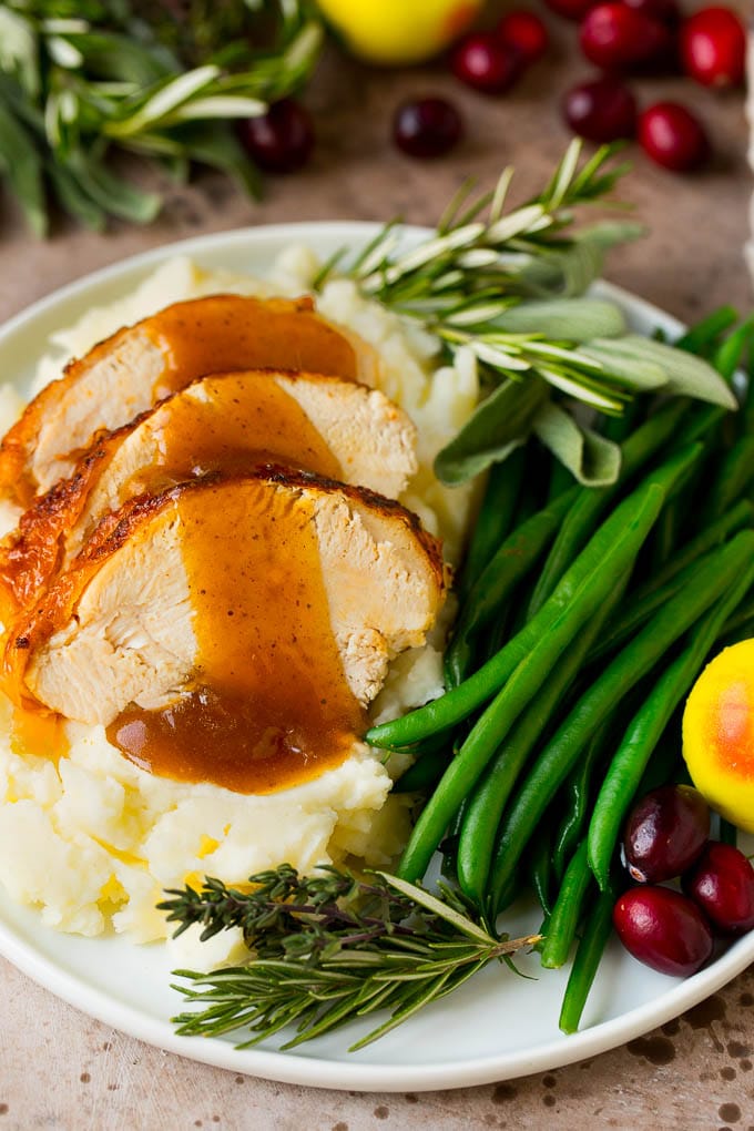 Instant Pot turkey breast sliced and served with mashed potatoes and gravy.