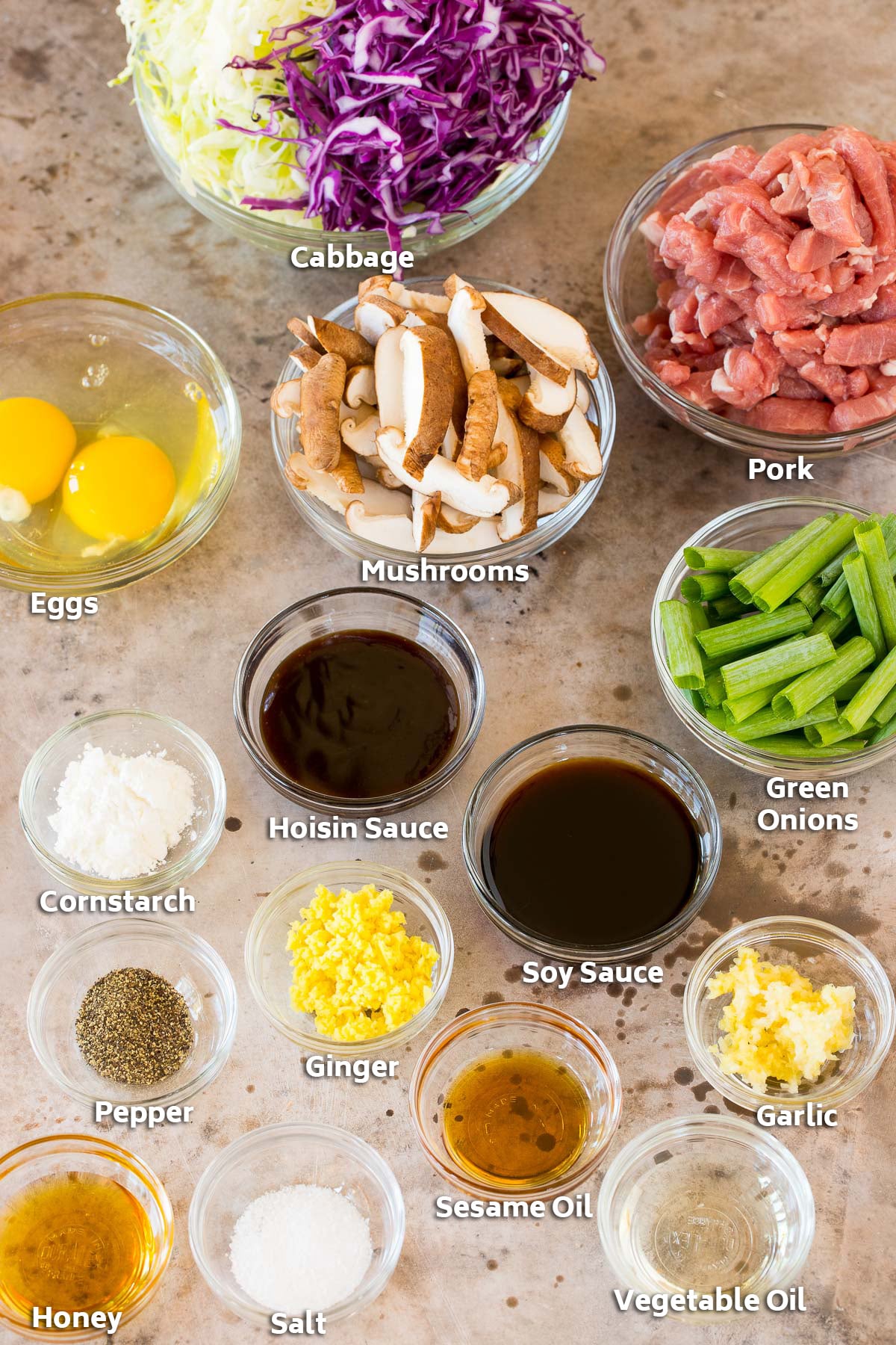 Bowls of ingredients including pork, vegetables, eggs and seasonings.