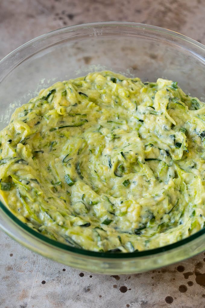 Batter to make zucchini pancakes in a mixing bowl.