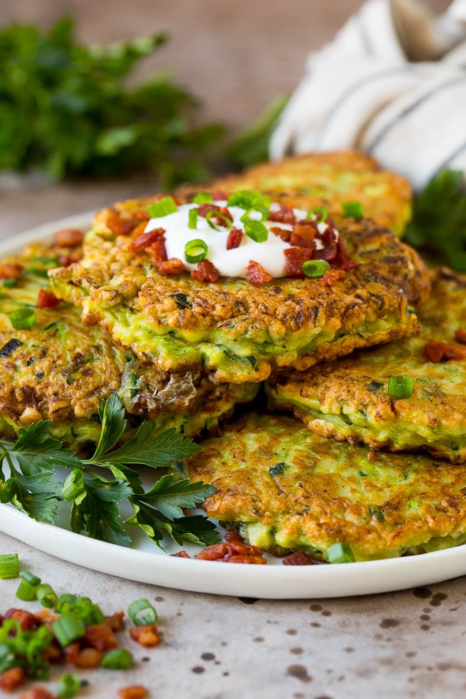 A plate of zucchini fritters garnished with fresh herbs.