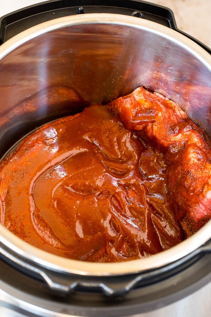 Brisket in a pressure cooker covered in sauce.