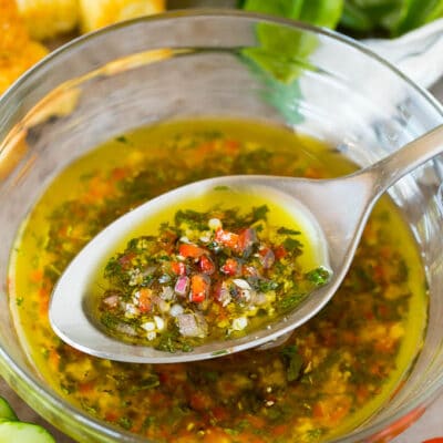 A bowl of homemade Italian dressing with a spoon in it.