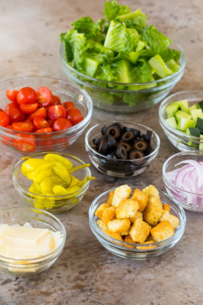 Bowls of lettuce, vegetables, cheese and croutons.