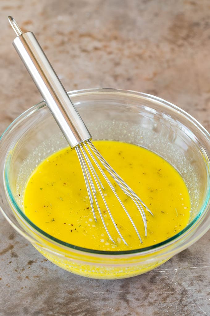 Homemade salad dressing in a bowl with a whisk.
