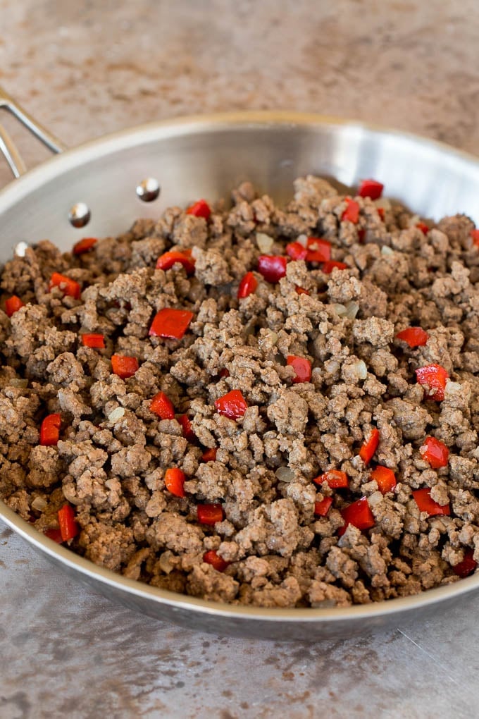 Ground beef and bell peppers in a skillet.