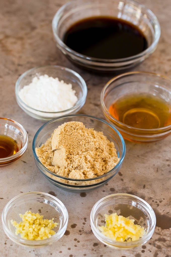 Glass bowls of ingredients including soy sauce, brown sugar, garlic and ginger.