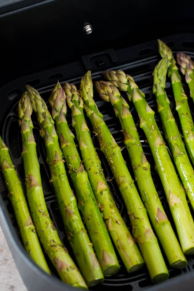 Asparagus in an air fryer basket.