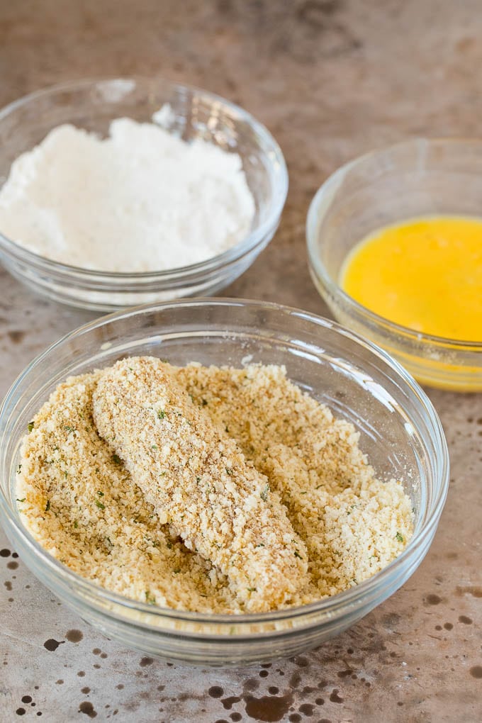 Chicken in a bowl of breadcrumbs.