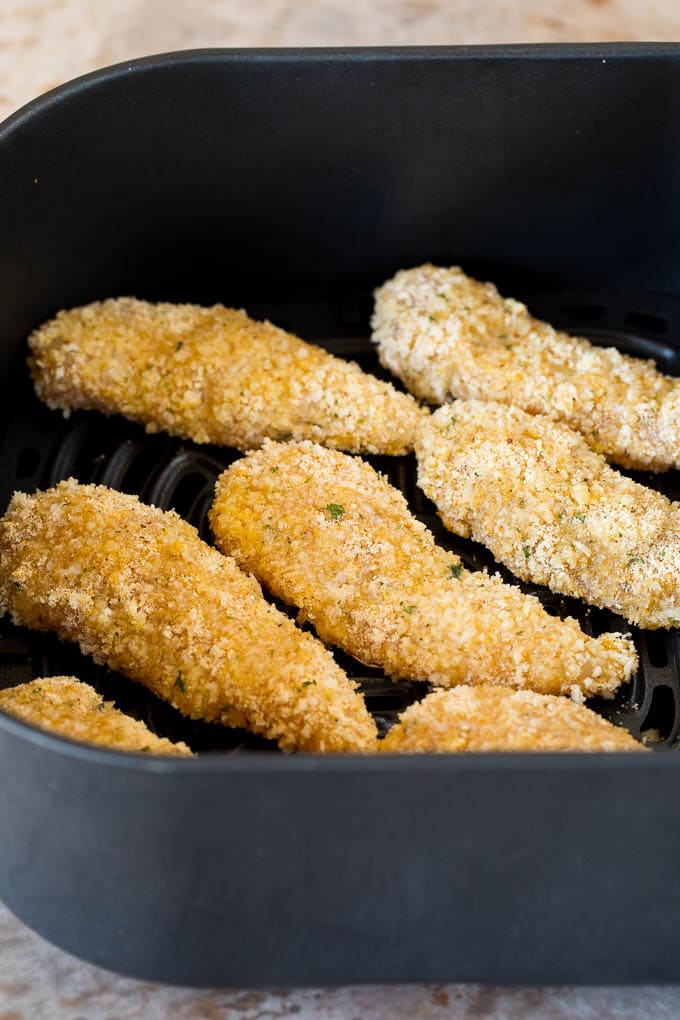 Breaded chicken pieces in an air fryer.