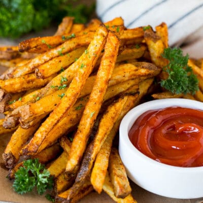 A plate of air fryer french fries garnished with parsley and served with ketchup.