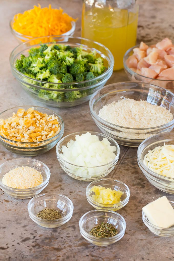 Bowls of ingredients including chicken, rice, cheeses and broccoli.