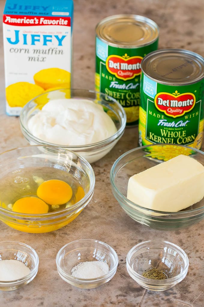 Bowls of ingredients with cans of corn and a box of corn muffin mix.