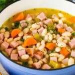 A pot of ham and beans garnished with parsley.