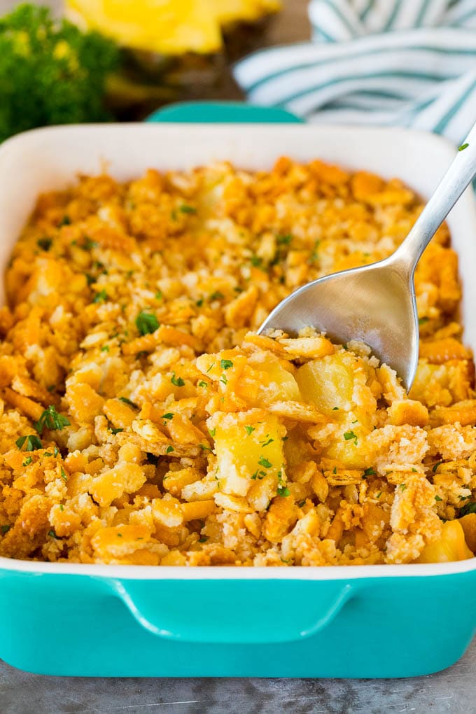 A serving spoon in a dish of pineapple casserole.