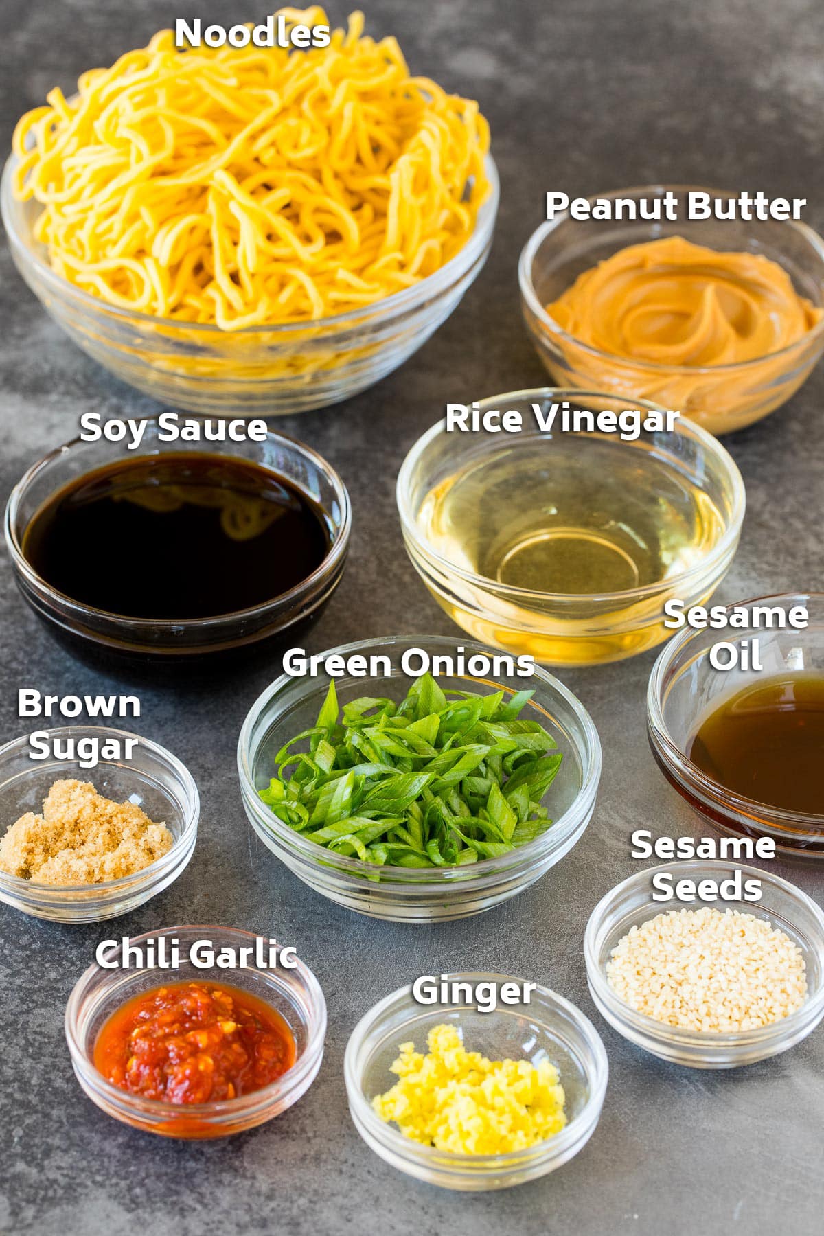 Bowls of ingredients including noodles, herbs, sesame oil, soy sauce and ginger.