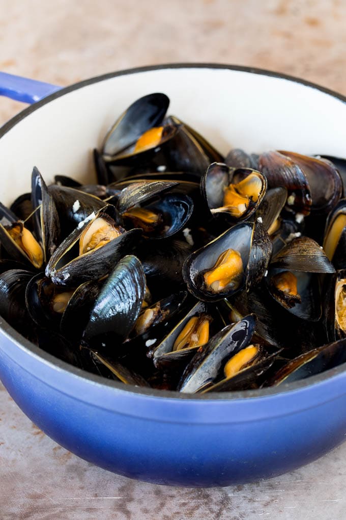 Cooked mussels in a blue pot.