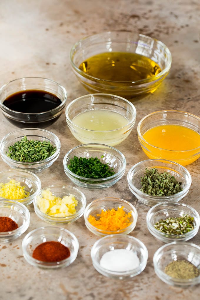 Bowls of olive oil, soy sauce, citrus juices, seasonings and herbs.