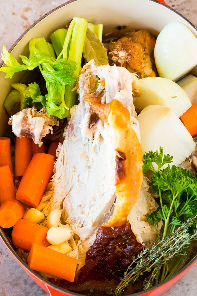 A turkey carcass in a pot with vegetables.