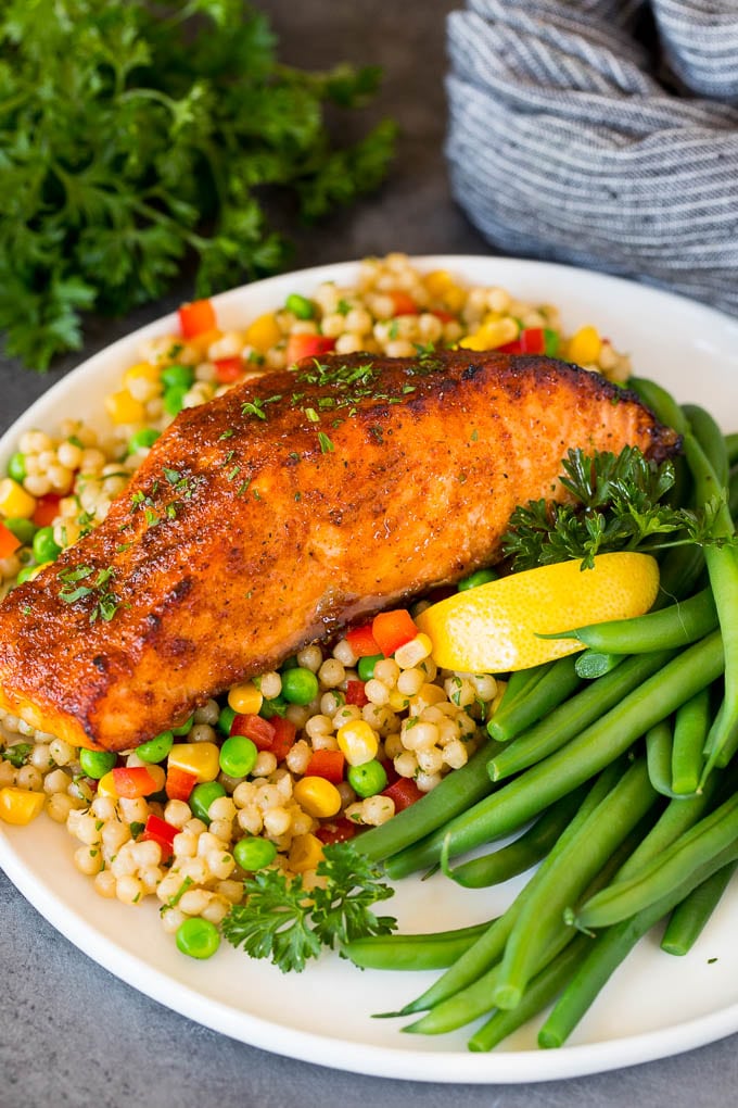 A piece of air fryer salmon served with couscous and green