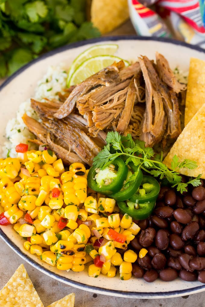 Corn salsa on a plate with black beans, carnitas and rice.
