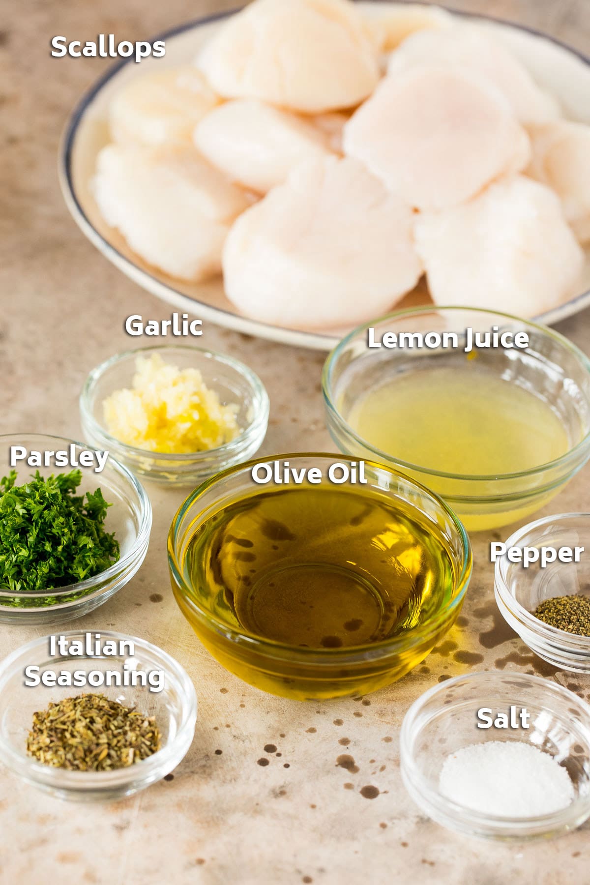 Bowls of marinade ingredients and a plate of raw scallops.