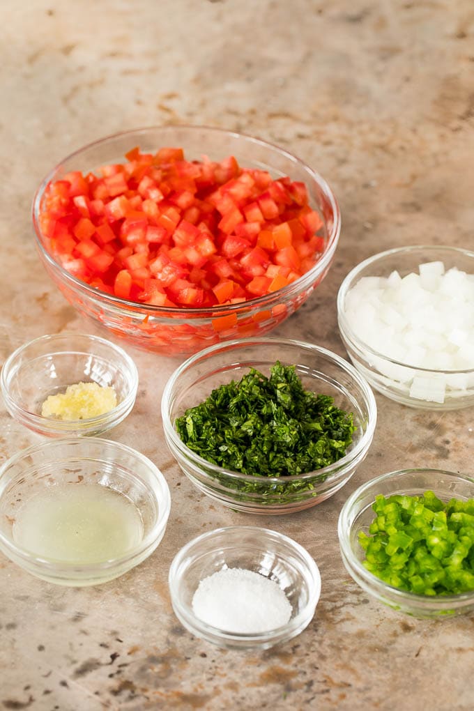 Bowls of tomatoes, cilantro, onion, jalapeno and seasonings.