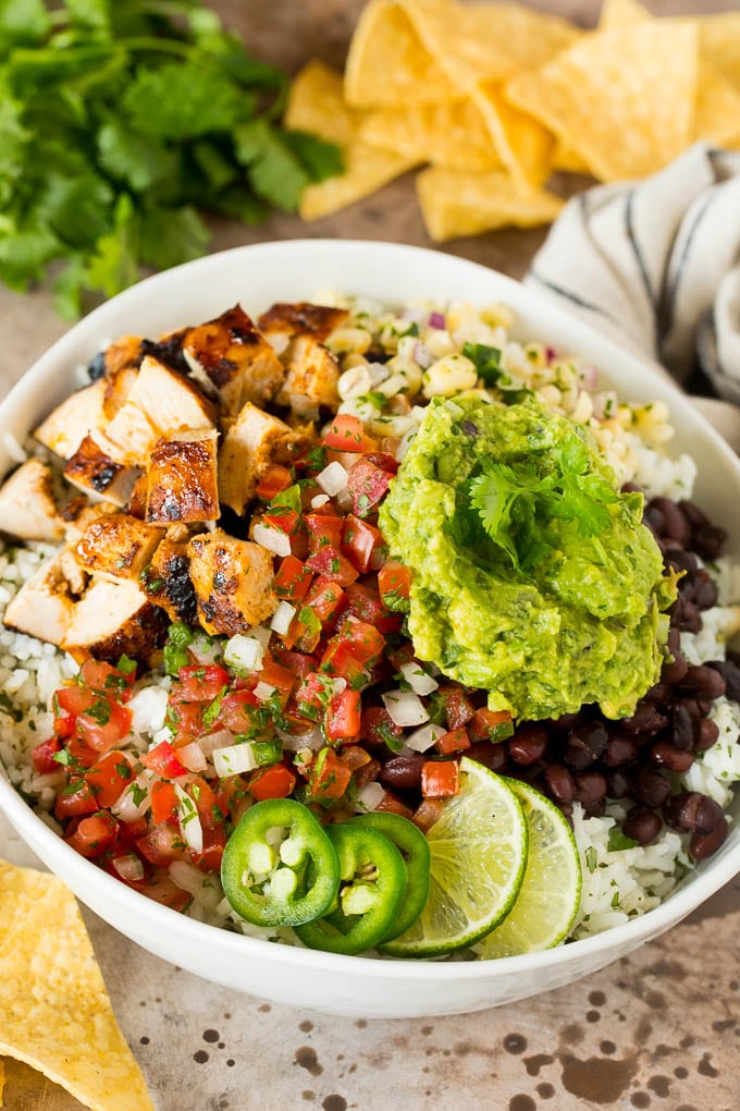 A burrito bowl with chicken, beans, rice and salsa fresca.