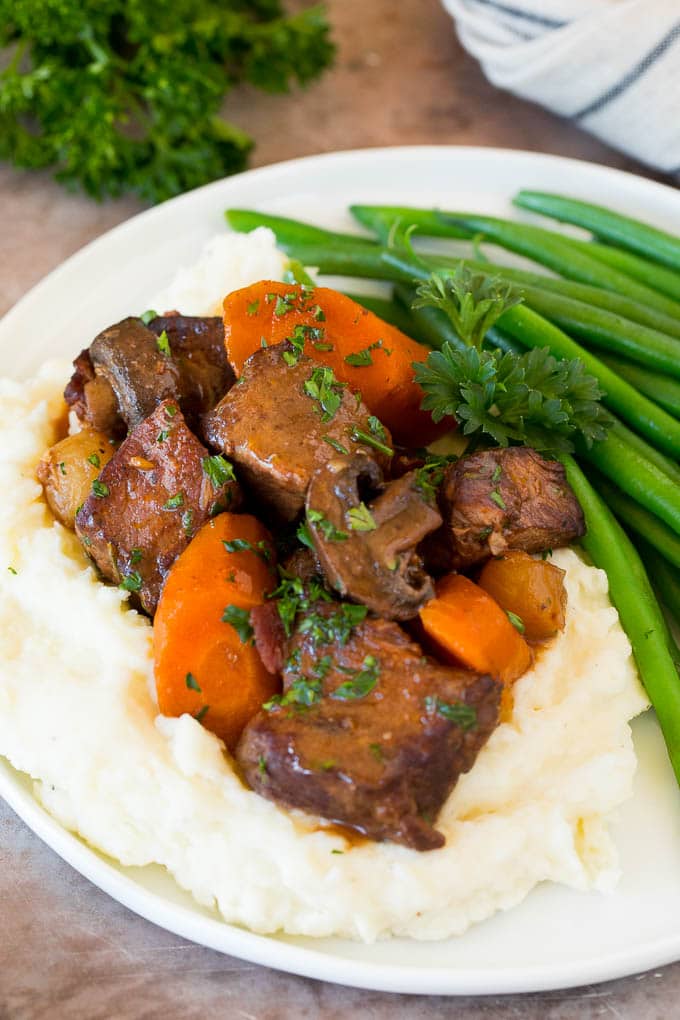 Slow cooker beef bourguignon with mashed potatoes and green beans.