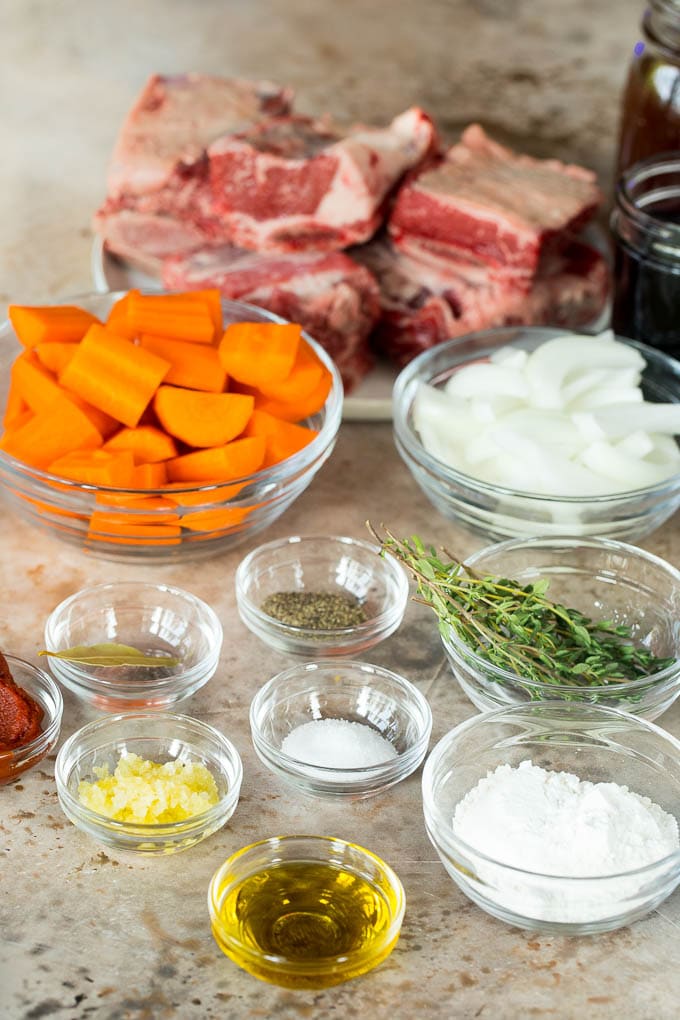 Bowls of ingredients including vegetables and seasonings, and a plate of short ribs.