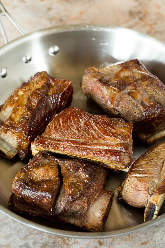 Seared short ribs in a pan.