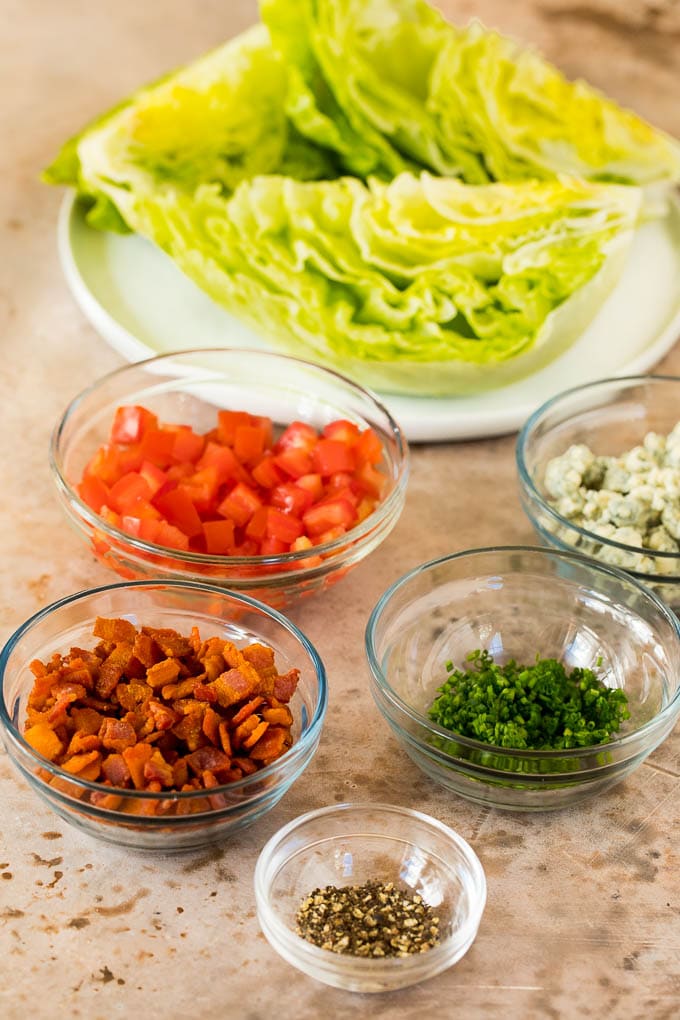 Bowls of bacon, tomatoes, chives, blue cheese and pepper.