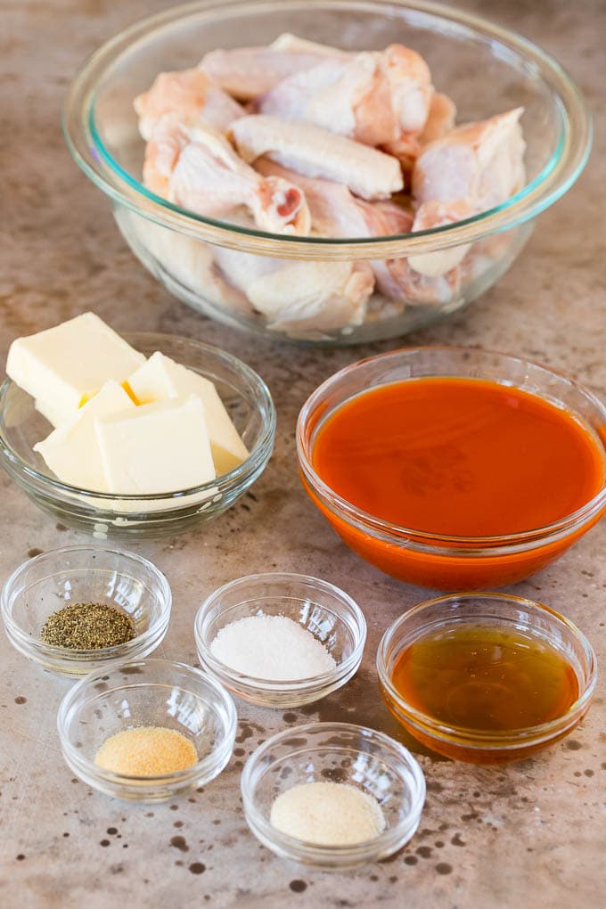 Bowls of chicken wings, hot sauce, butter and seasonings.