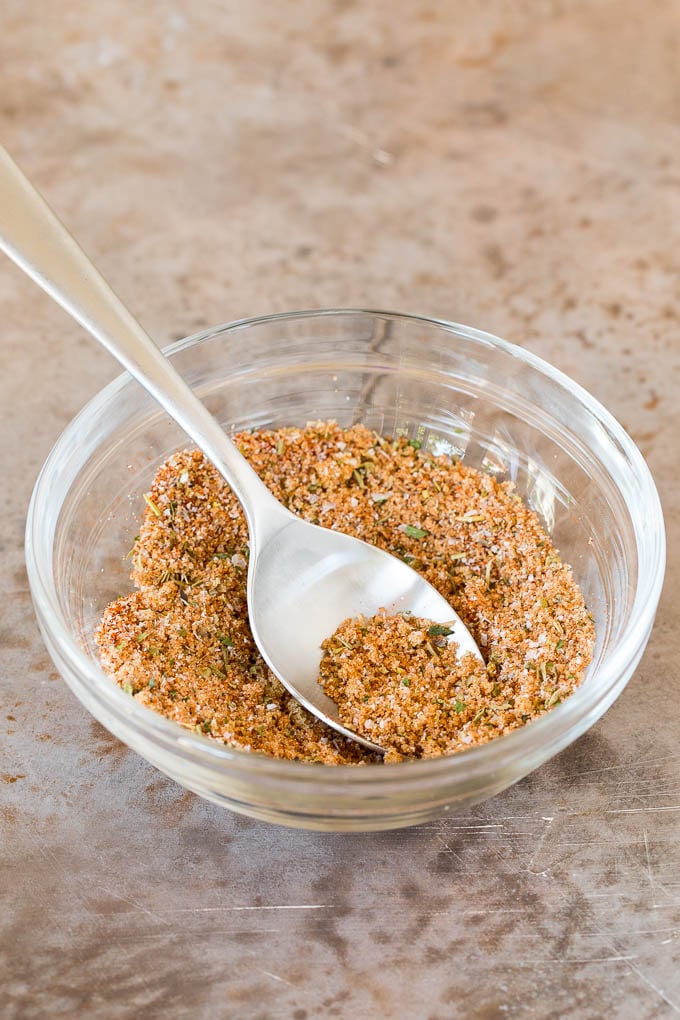 A spice mix in a bowl with a spoon.