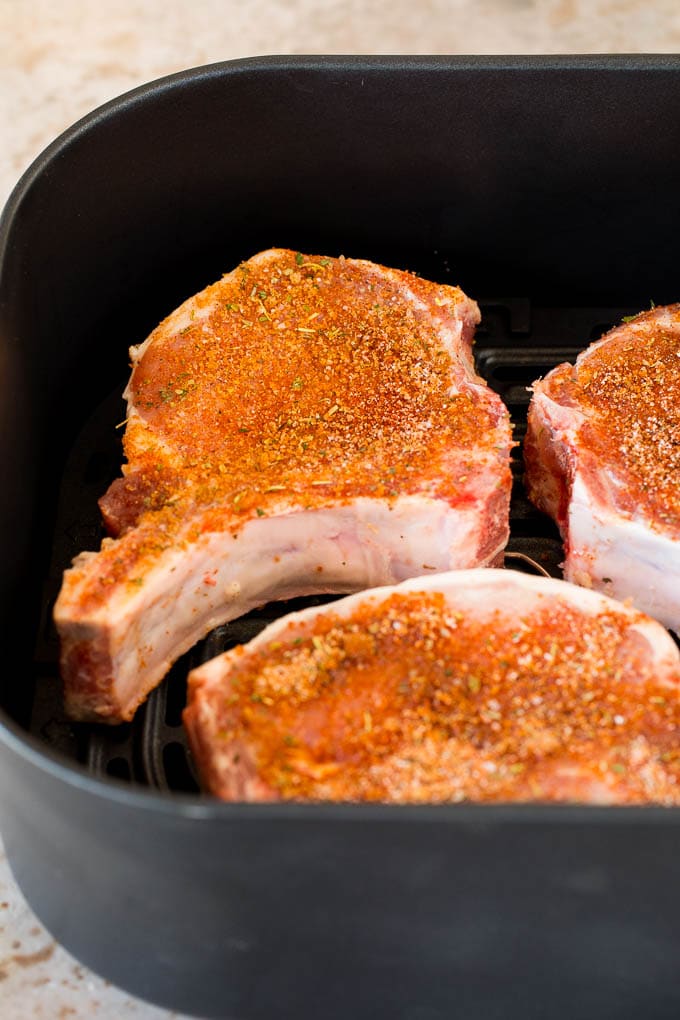 Spice coated pork chops in an air fryer.