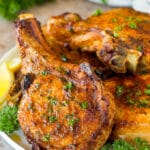 A plate of air fryer pork chops garnished with parsley.