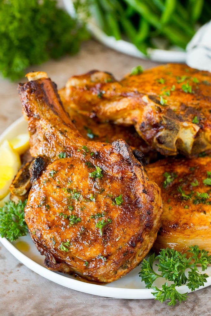 A plate of air fryer pork chops garnished with parsley.