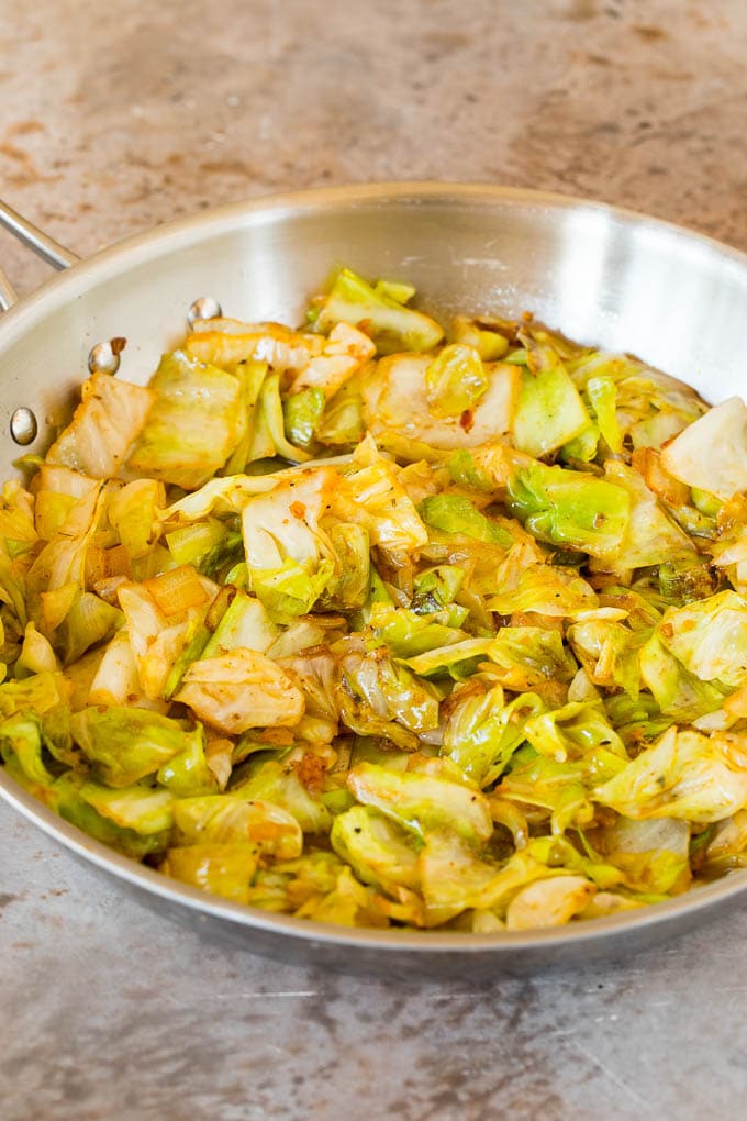 Sauteed cabbage with seasonings in a skillet.