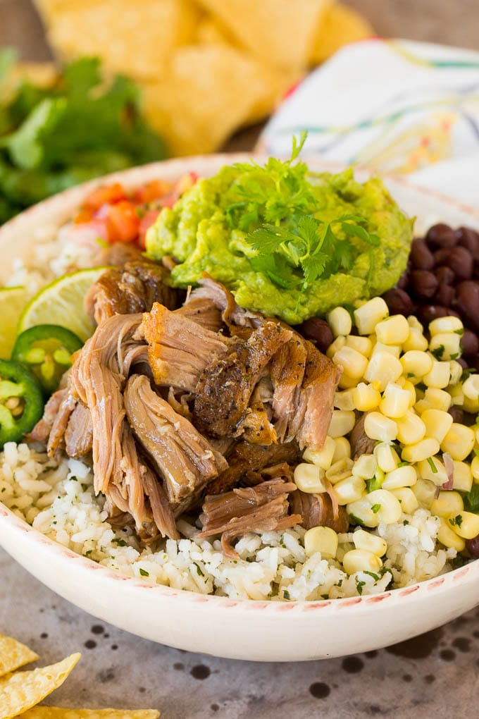 A bowl of Chipotle carnitas with cilantro rice, corn salsa and guacamole.