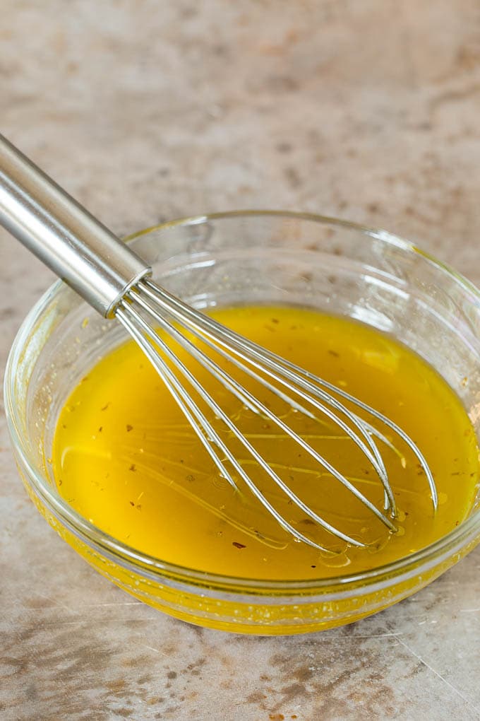 Homemade salad dressing in a bowl with a whisk.