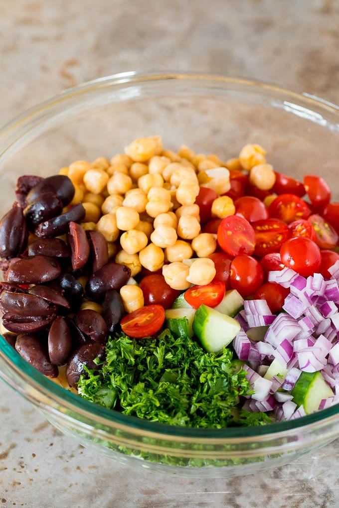 Olives, tomatoes, cucumber, onions and parsley in a bowl of couscous.