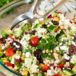 A bowl of couscous salad garnished with parsley.