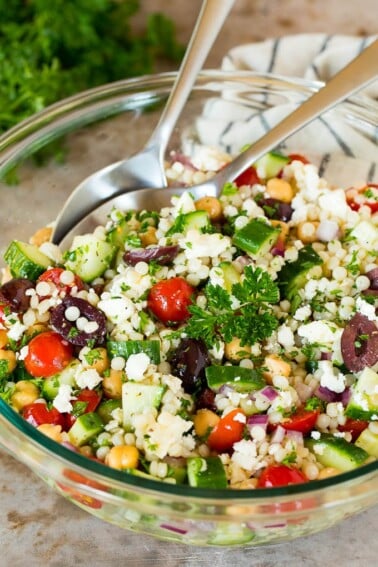 A bowl of couscous salad garnished with parsley.